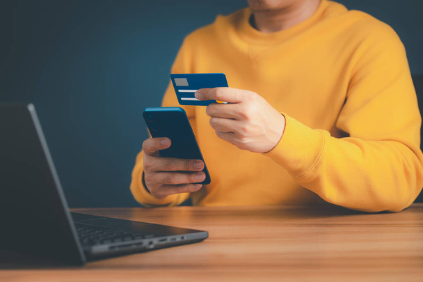 A man using credit card for purchasing and shopping online on mobile phone. Mobile payment with wallet app technology. Digital money transfer, banking and e commerce concept. - Foto, Imagen