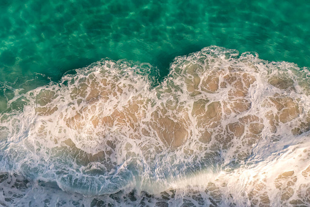 海岸岩に海の波の影響から白い泡のパターンのトップビュー。南アフリカ - 写真・画像