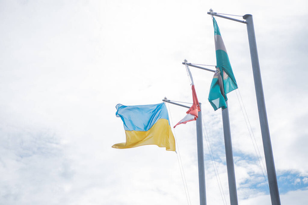 Poland, Warsaw - July 2022. Ukrainian flag on flagpole, near Poland flag. High quality photo - Foto, immagini