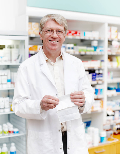 Farmacéutico sonriente en la farmacia. Retrato de farmacéutico sonriendo con receta en farmacia - Foto, Imagen