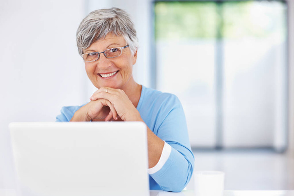 Mature woman using laptop. Portrait of smiling mature woman using laptop - Valokuva, kuva