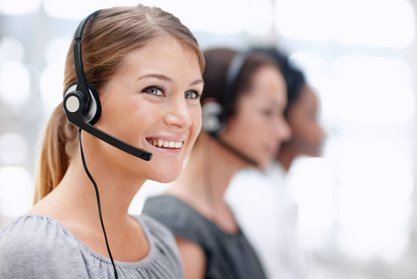 Every customer is satisfied. Pretty young call operator smiling as she works - Valokuva, kuva