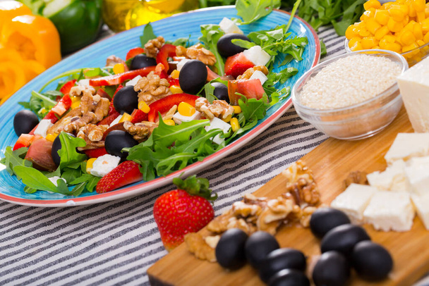 Image of ready-made salad and its ingredients on the table indoors. - Photo, Image