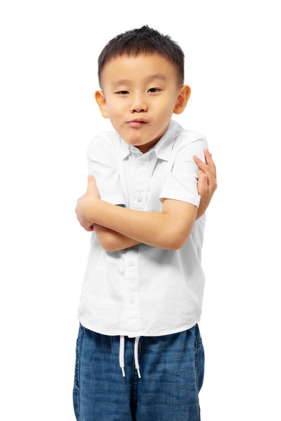 Παιδική σταυρωτά χέρια με αστεία ενοχλημένη φάτσα, φορώντας λευκό πουκάμισο απομονωμένο σε λευκό φόντο - Φωτογραφία, εικόνα