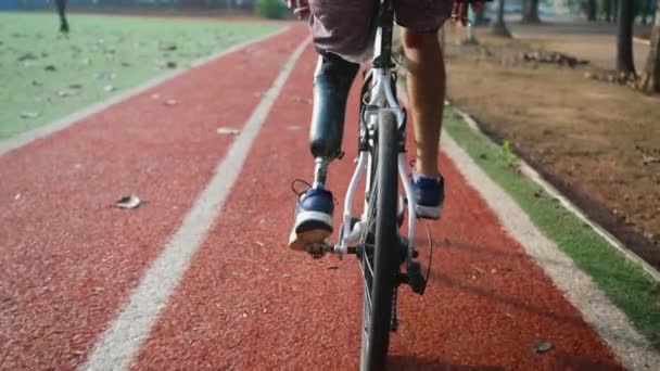 Disabled person riding bicycle with prosthetic leg - Footage, Video