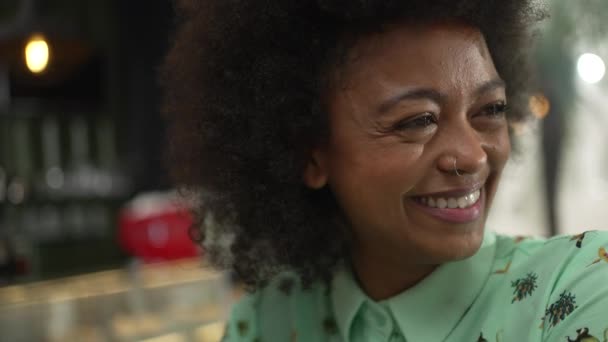 Een jonge zwarte vrouw die luistert naar een vriend die een close-up gezicht spreekt. Afro-Amerikaans glimlachen. - Video