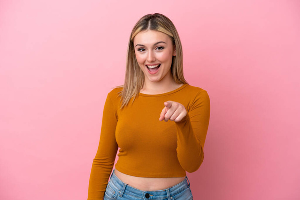 Jovem mulher caucasiana isolado no fundo rosa surpreso e apontando frente - Foto, Imagem