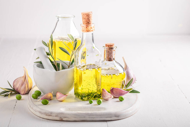 Aromatic and healthy oil in bottle with garlic. Products made of olives and garlic. - Foto, Bild
