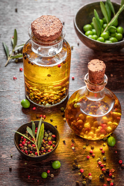 Fresh and healthy oil in bottle with mix of peppers. Products made of olives and peppers. - Photo, image