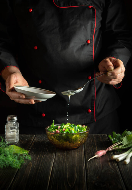 O chef profissional adiciona creme azedo a uma salada de legumes frescos. Cozinhar comida deliciosa na cozinha. Receita de menu para restaurante ou hotel - Foto, Imagem