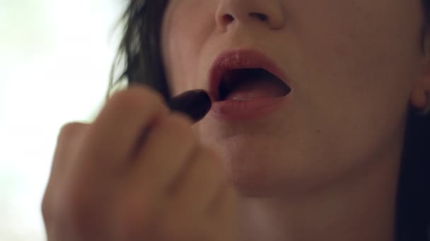 Close-up van een meisje dat haar lippen schildert. Make-up thuis met lippenstift. Een mooie vrouw bereidt zich voor op een feestje. Hoge kwaliteit 4k beeldmateriaal - Video