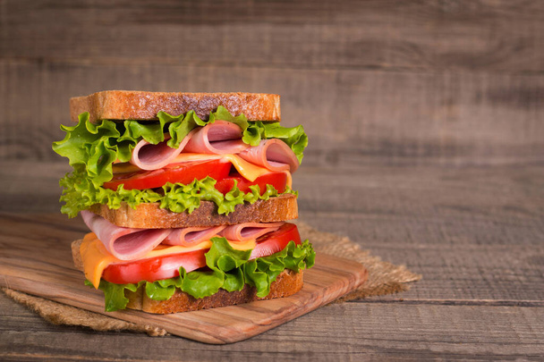 Club sandwich with ham, cheese, tomato and lettuce.  - Fotoğraf, Görsel