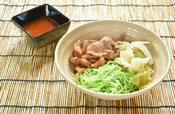 Korean fried slice pork with cabbage topping Chinese jade noodles dipping sukiyaki sauce on bowl - Photo, Image