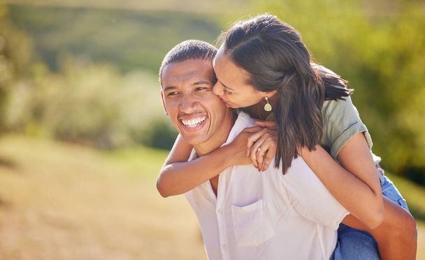 Love, date and outdoor couple in park playing on holiday, vacation or healthy lifestyle with green trees, bokeh and summer sun. Happy, wellness black people piggyback ride together or nature hiking. - Photo, Image