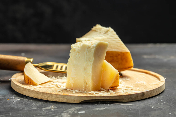 Gruyere класифікується як швейцарський або альпійський сир, солодкий, але злегка солоний, зі смаком, який змінюється з віком, місце для тексту., - Фото, зображення