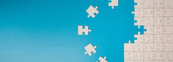 White part of jigsaw puzzle pieces on blue background. concepts of problem solving, business success, teamwork, Team playing jigsaw game incomplete, Texture photo with copy space for text - Photo, Image