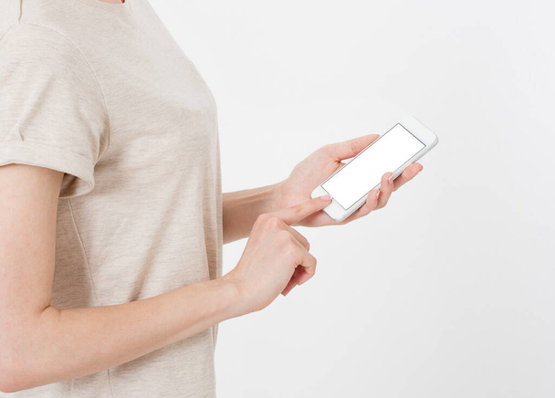 mujer muestra pantalla en blanco del teléfono móvil, puntos de mano al dispositivo, pantalla en blanco celular - Foto, imagen