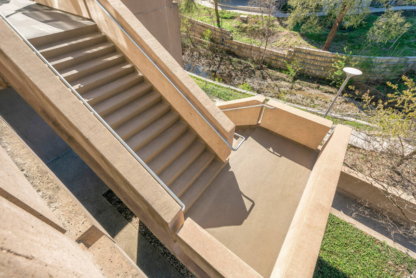 Widok z góry schodów zewnętrznych wchodzących do budynku w Austin Texas. Patrząc na schody z betonowymi stopniami i metalowymi balustradami w słoneczny dzień. - Zdjęcie, obraz