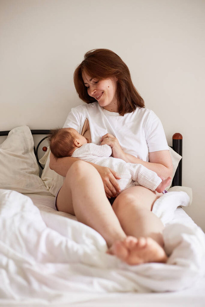 Mother breastfeeding her newborn baby boy. Realistic home portrait - Foto, Bild