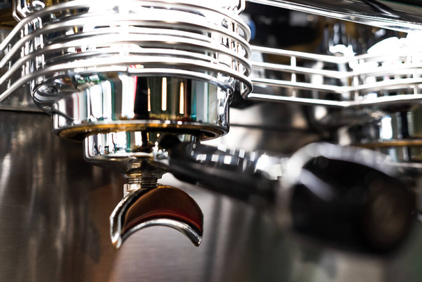 close up of a shiny and gleaming professional coffee maker from a coffee shop. handle is out of focus.  - 写真・画像