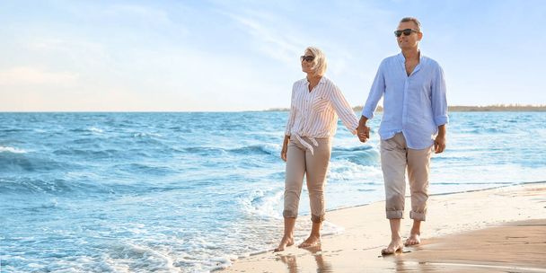 Happy mature couple walking on sea beach - Fotografie, Obrázek