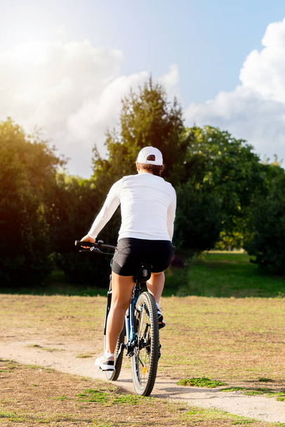 Молода жінка насолоджується сонячним днем, катаючись на велосипеді в міському парку. Високоякісна фотографія
 - Фото, зображення