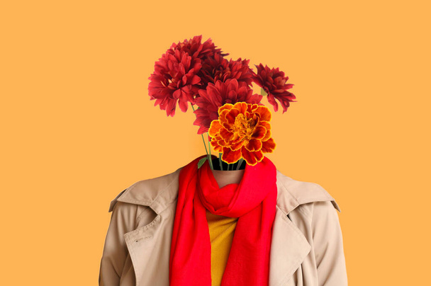 Femme en vêtements d'automne et avec bouquet de fleurs fraîches au lieu de sa tête sur fond orange - Photo, image