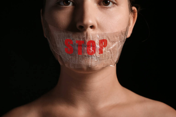 Woman with taped mouth on dark background. Censorship concept - Photo, Image