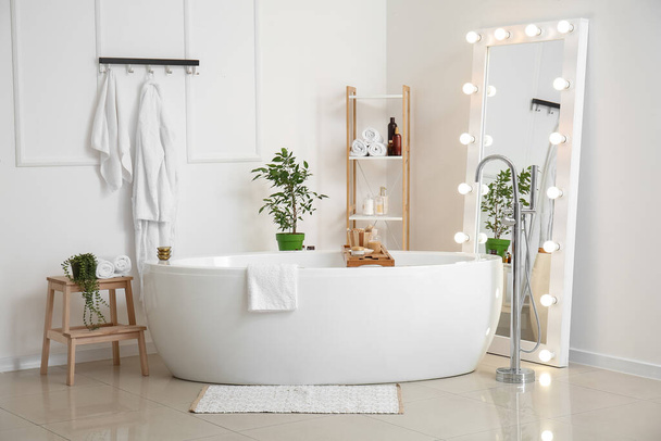 Aynalı, raflı ve çiçekli şık bir banyo. - Fotoğraf, Görsel