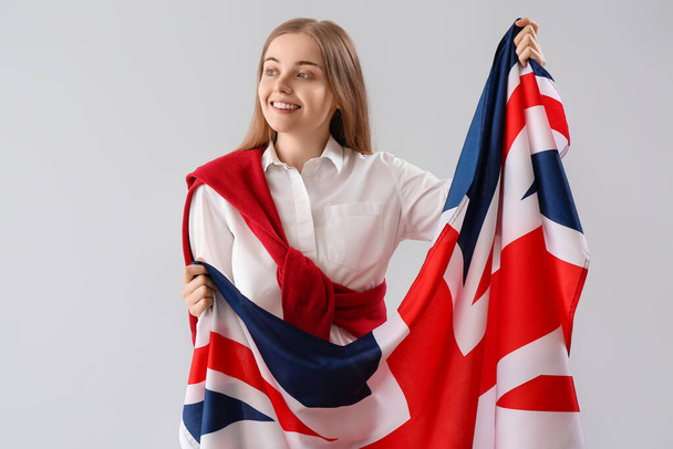 Young woman with UK flag on light background - Zdjęcie, obraz