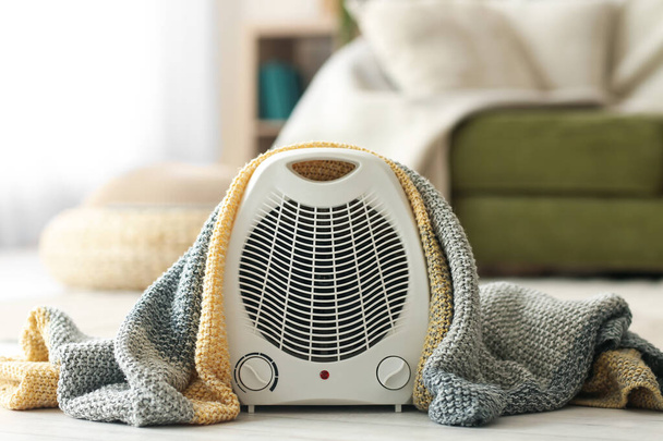 Elektromos ventilátor fűtőberendezés meleg kockás padlóval a nappaliban - Fotó, kép