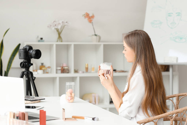 Female beauty blogger with eyeshadows recording video in dressing room - Valokuva, kuva
