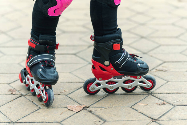 Legs of a child rollerblading in the park. - Фото, зображення