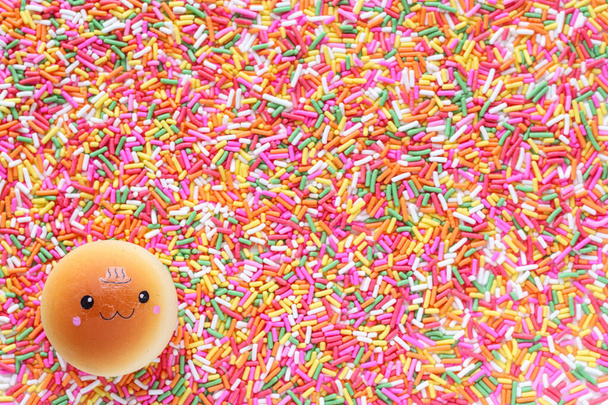 lahodný toust je nastaven na pozadí mnoha pestrobarevných cukerných granulí používaných pro polevy dezertů a zmrzliny v Top View barevné pozadí, které je ideální pro design akce - Fotografie, Obrázek