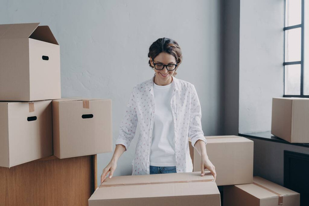 Happy businesswoman packing parcels of her online store, smiling woman looking at cardboard box, satisfied female businessperson preparing orders for sending. Small business, startup concept. - Fotoğraf, Görsel