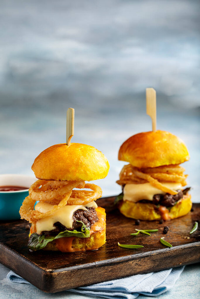 brüllender Rindfleisch-Slider-Burger, serviert in einer Schüssel Seitenansicht isoliert auf einem Holztisch - Foto, Bild