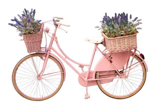 Oude schattige roze geschilderde fiets met manden en bloemen in de lente geïsoleerd op wit voor eenvoudige selectie - Fashion Cut Out concept - Foto, afbeelding