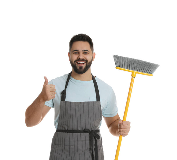 Young man with yellow broom on white background - Fotó, kép