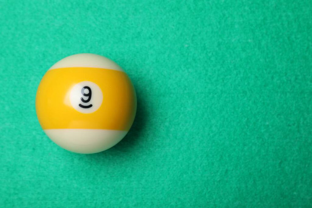 Billiard ball with number 9 on green table, top view. Space for text - Фото, изображение