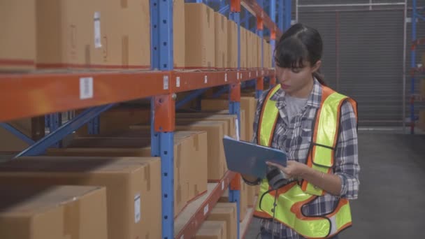 Young caucasian woman worker checking with scanning barcode and writing record document on clipboard for distribution cargo in the warehouse at factory, transportation and shipping, logistic concept. - Imágenes, Vídeo