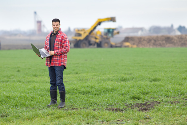 Peasant with laptop in field - Photo, Image