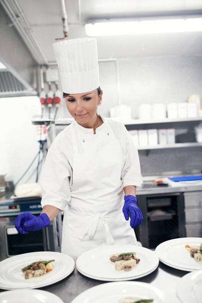 Out of the kitchen and on to your table. a chef plating food for a meal service in a professional kitchen - Foto, Imagen