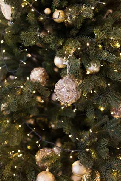 Hermoso árbol de Navidad con decoraciones doradas vintage y luces de Navidad - Foto, imagen