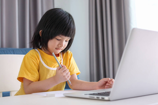 kleine asiatische Mädchen studieren online mit Laptop-Computer zu Hause - Foto, Bild