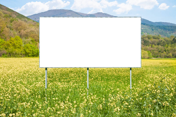 Leere Werbetafel in ländlicher Umgebung vor gelbem Blumenfeld - Bild mit Kopierraum - Foto, Bild