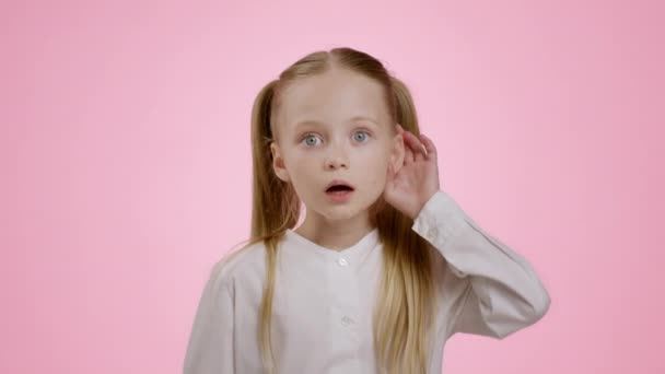 Шокуючі розмови для дорослих. Крупним планом портрет приголомшеної маленької дівчинки, що чує вбік руками біля вуха і прикриває рот з подивом, рожевий студійний фон, повільний рух
 - Кадри, відео