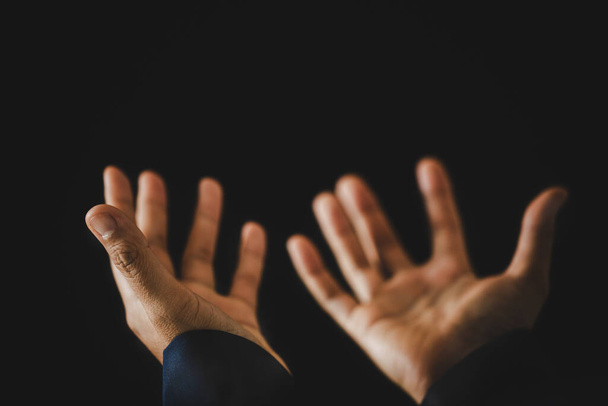 Χέρι διπλωμένο προσευχή στο Θεό στο σκοτάδι στην εκκλησία έννοια για την πίστη, την πνευματικότητα και τη θρησκεία, γυναίκα πρόσωπο προσεύχεται στην Αγία Γραφή το πρωί. Χριστιανική καθολική γυναίκα χέρι με λατρεία σε μαύρο φόντο. - Φωτογραφία, εικόνα