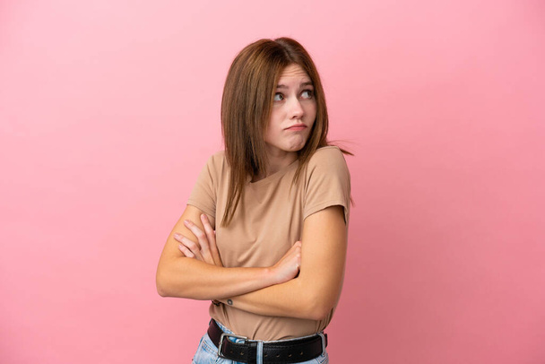 Junge Engländerin isoliert auf rosa Hintergrund macht Zweifel Geste beim Heben der Schultern - Foto, Bild