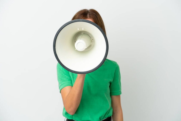 Νεαρή Αγγλίδα απομονωμένη σε λευκό φόντο φωνάζοντας μέσα από ένα μεγάφωνο για να ανακοινώσει κάτι - Φωτογραφία, εικόνα