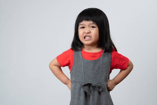 Retrato de niña asiática enojada y triste sobre fondo blanco aislado, La emoción de un niño cuando rabieta y loca, expresión emoción gruñona. Concepto de control emocional infantil - Foto, imagen